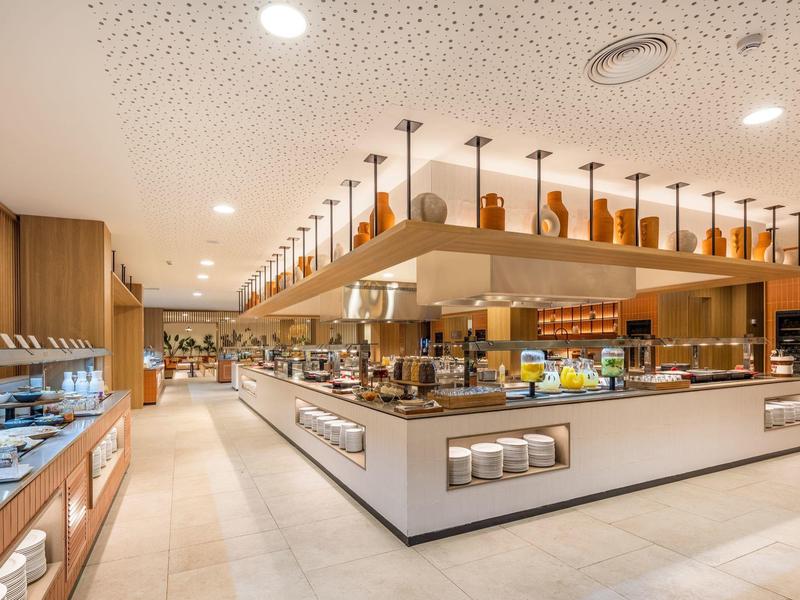 Modern, licht hotelbuffet met een breed aanbod van eten en stijlvolle verlichting.