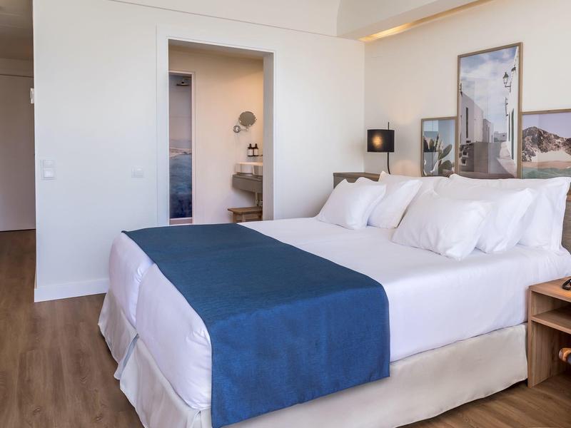 Moderne slaapkamer met groot bed, blauwe loper en minimalistisch ontwerp.