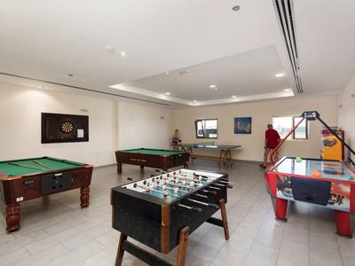 Moderner Spielraum mit Billardtischen, Kicker, Airhockey und Tischtennis in hellem Raum.