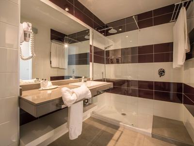 Bagno d'hotel moderno con vasca, asciugamani e specchio ingranditore.