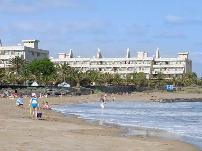 Spiaggia con persone, mare e edificio dell'hotel sullo sfondo sotto un cielo azzurro