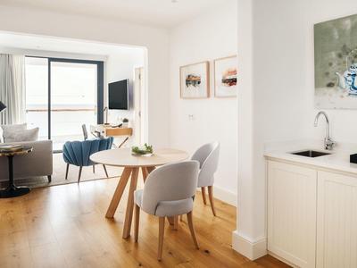 Moderne helle Wohnung mit Holzboden, Esstisch, Stühlen, Sofa und großen Fenstern für viel Licht.