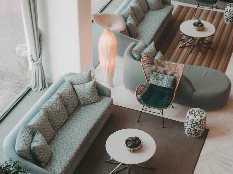 Soggiorno moderno e accogliente con divani, poltrone e grandi finestre.