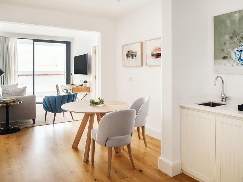 Soggiorno e sala da pranzo moderni con pavimento in legno e grandi finestre.
