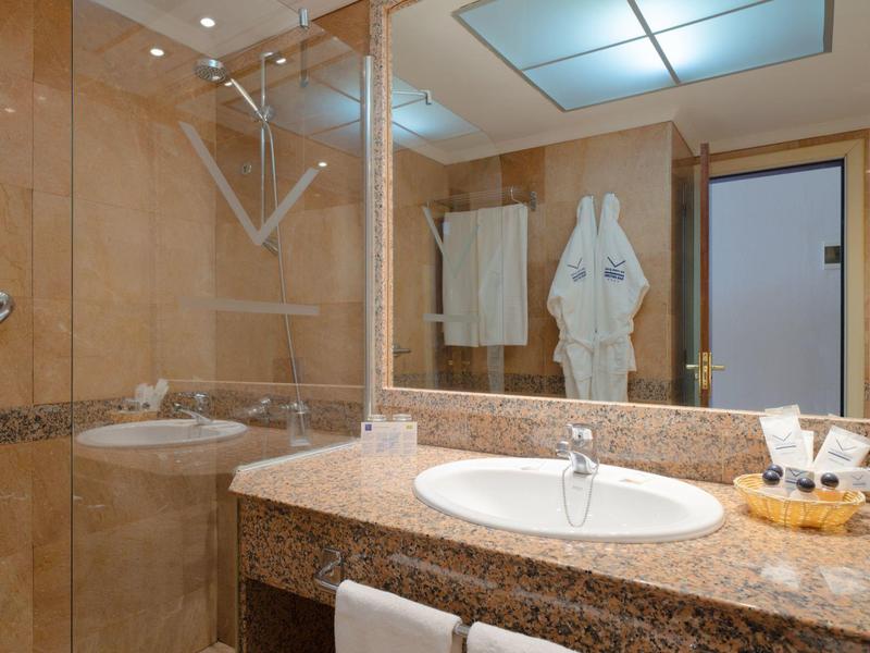 Bagno d'albergo con lavabo in granito, specchio e asciugamani