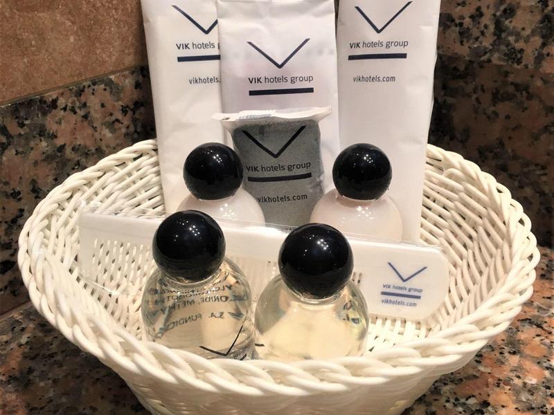 Cestino in plastica bianca con prodotti da bagno dell'hotel su superficie in marmo