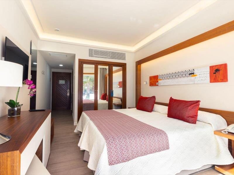 Camera d'hotel moderna con letto matrimoniale grande, TV a schermo piatto e balcone