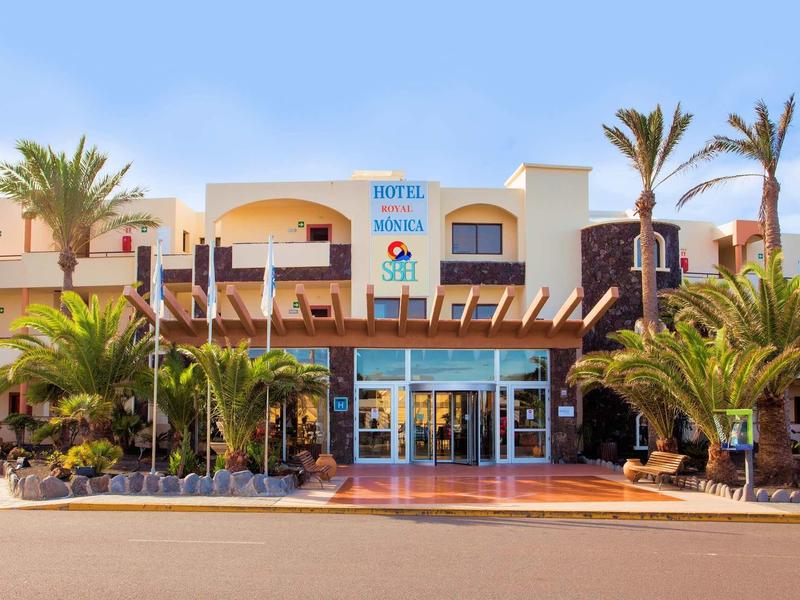 Hôtel avec palmiers et façade vitrée sous ciel clair