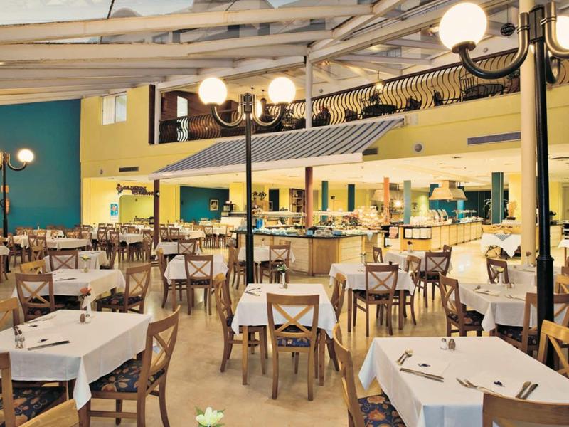 Restaurant lumineux et spacieux avec de nombreuses tables et chaises sous un plafond en bois.