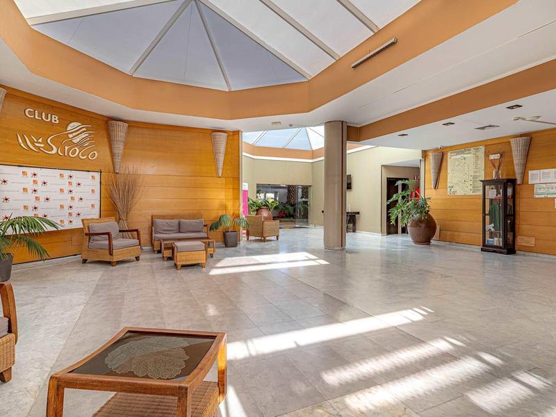 Heller, moderner Wartebereich mit Holzmöbeln, hellem Fußboden und großem Panorama-Dachfenster.