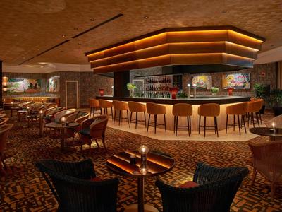 Elegante Hotelbar mit warmem Licht, Holzmöbeln und gemütlicher Atmosphäre.