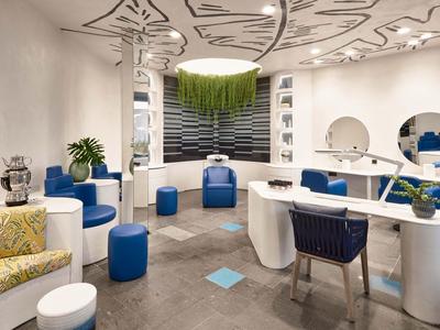 Espace lounge moderne avec sièges ronds et plafond décoratif dans une pièce lumineuse.