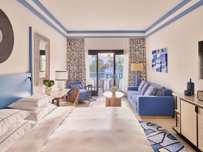 Chambre d'hôtel moderne avec lit double et coin salon près du balcon