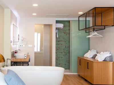 Moderne Badezimmer mit freistehender Badewanne, Waschtisch, Duschkabine und Holzschrank.