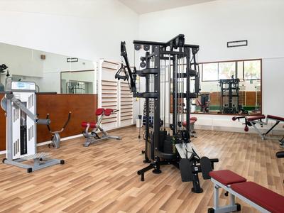 Modern gym with workout machines and bright walls in a hotel.