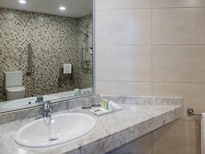 Moderner Badezimmerwaschtisch mit Marmorplatte, integriertem Waschbecken und großem Spiegel.