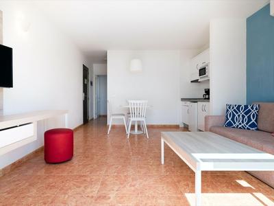 Moderner Wohnbereich mit Sofa, Couchtisch, Fernseher und Essbereich in einer hellen Wohnung.