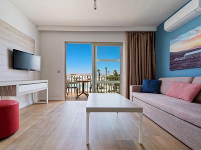 Modern eingerichtetes Hotelzimmer mit Balkon und Meerblick.