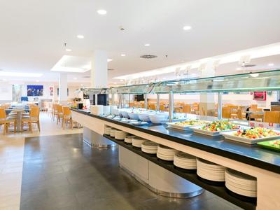 Heller Hotel-Speisesaal mit Buffet und Sitzbereichen aus Holz.