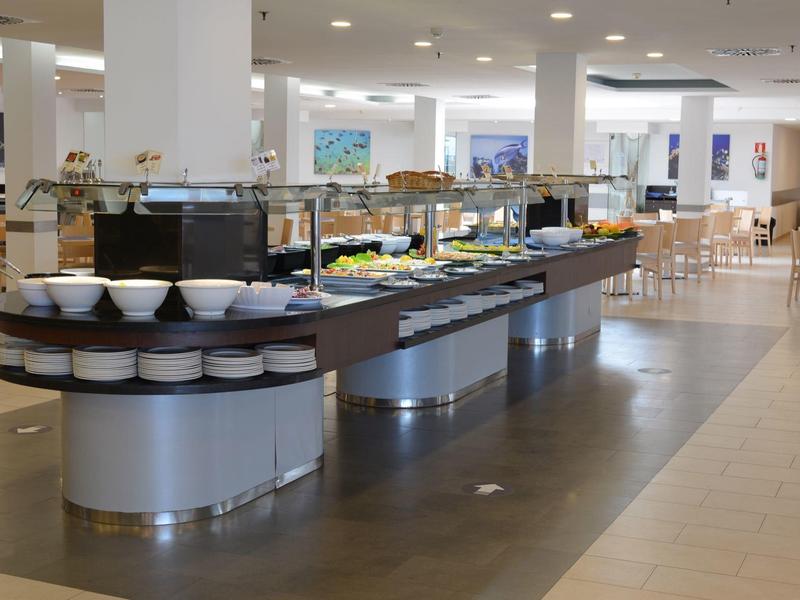 Buffet moderno con una varietà di piatti e ciotole in un ampio spazio ristorante.
