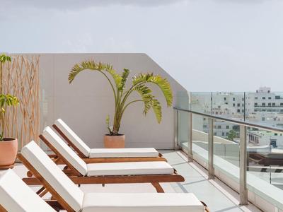 Moderne Terrasse mit Liegestühlen und Pflanze mit Blick auf die Stadt