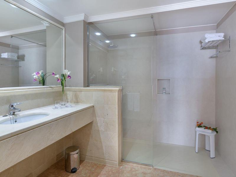 Nowoczesna łazienka z przestronnym prysznicem i podwójną umywalką w neutralnych kolorach.