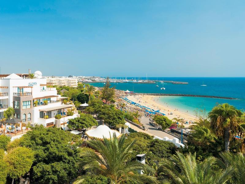 Plage et bâtiments d'hôtel le long de la côte sous un ciel clair avec beaucoup de monde