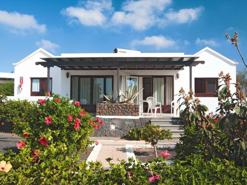 White holiday house with terrace and garden in sunny weather