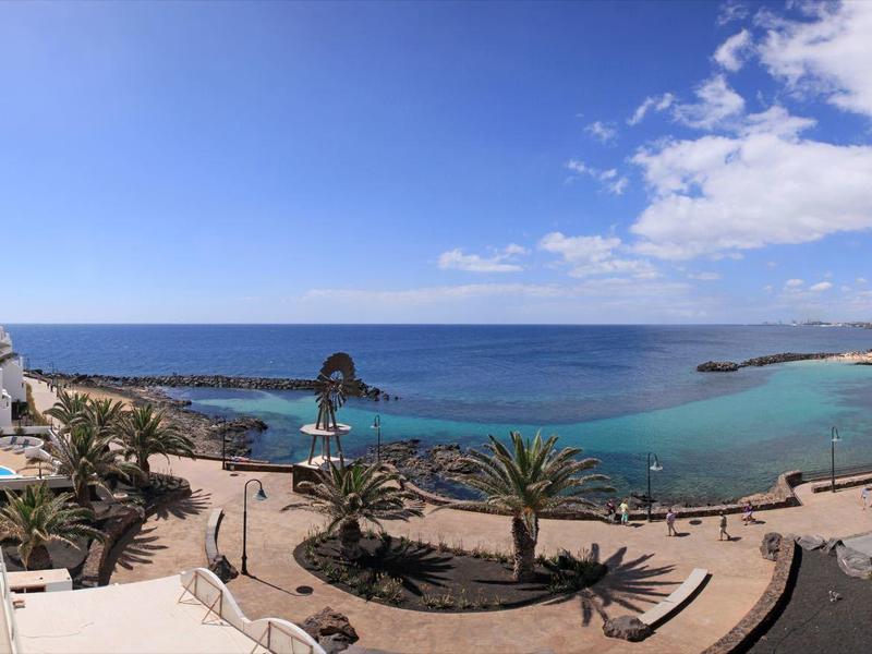 Panoramic view of coast with beach, sea, and hotel area under clear sky