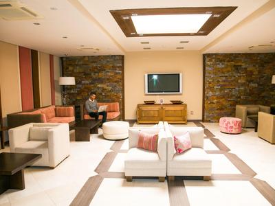 Pohodlný hotelový salonek s moderním nábytkem, kamennými zdmi a teplým osvětlením.