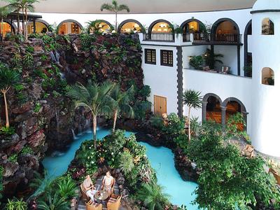 Rezort s bílými budovami, tyrkysovým kanálem a bujnou zelení.