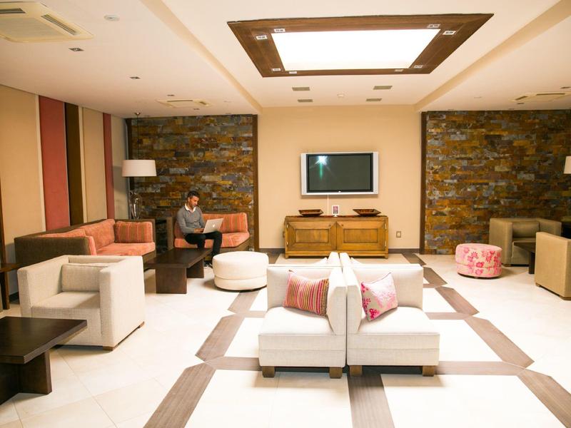 Pohodlný hotelový salonek s moderním nábytkem, kamennými zdmi a teplým osvětlením.