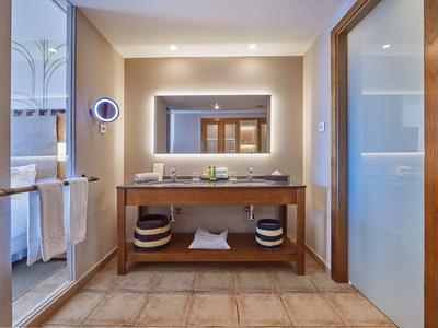 Bagno d'hotel moderno con grande specchio, doppi lavandini e specchio illuminato