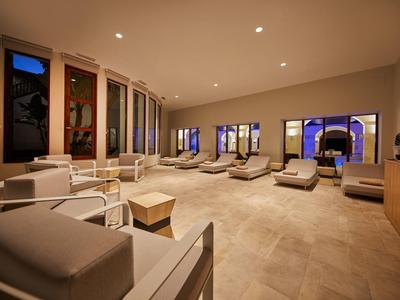 Lounge moderna con poltrone confortevoli, grandi finestre e illuminazione soffusa in un hotel.