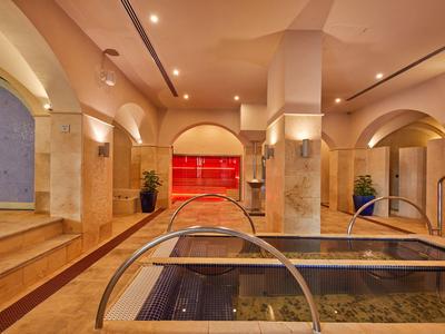 Interno di un'area spa di lusso con piscina riscaldata e illuminazione calda.