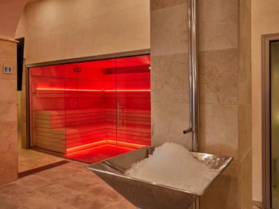 Area benessere moderna con illuminazione rossa e secchio di cubetti di ghiaccio.