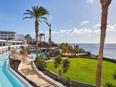 Resort con piscina, palme e vista mare in una giornata di sole