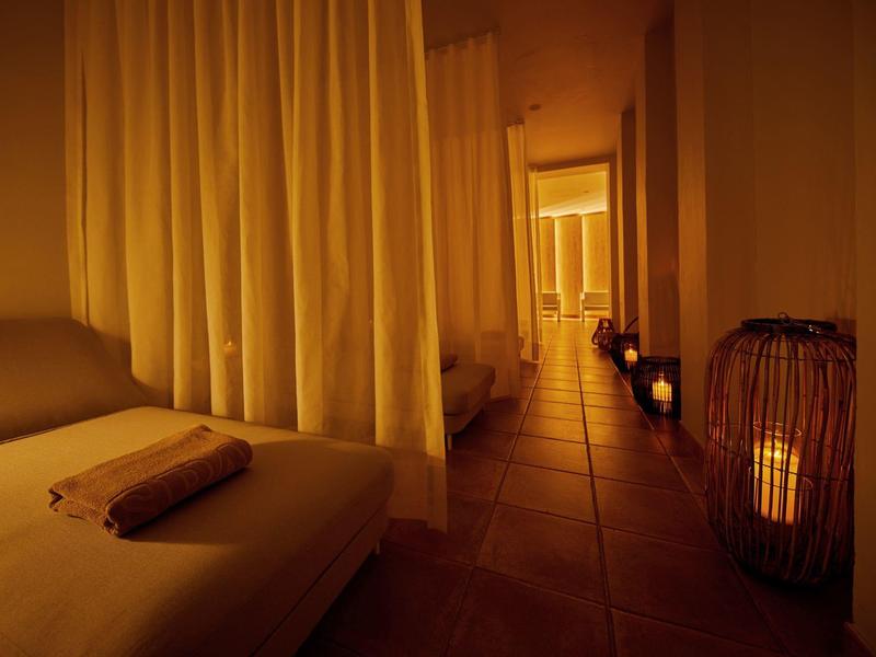 Un'area spa accogliente con lettini e illuminazione soffusa da lanterne.