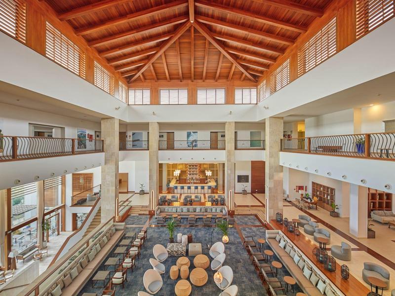 Ampia hall dell'hotel con soffitti alti in legno e aree salotto confortevoli.