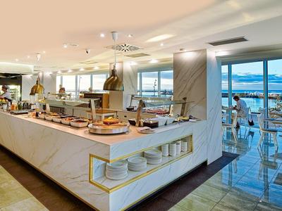 Ristorante moderno dell'hotel con area buffet e grandi finestre con vista sul mare.