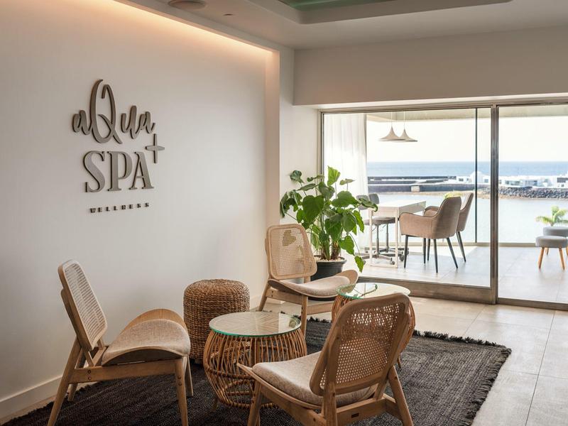 Area spa moderna con sedie in rattan e vista sul terrazzo e sul mare