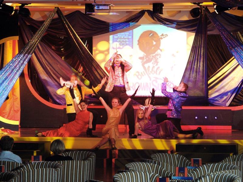 Camera d'hotel moderna con letto, scrivania e balcone con vista mare.