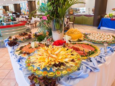 Buffet mit einer Vielfalt an dekorierten Speisen auf einem mit blauem Tuch bedeckten Tisch