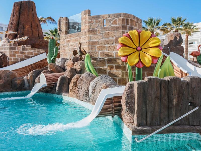 Parc aquatique coloré pour enfants avec toboggans et jeux d'eau dans l'hôtel.