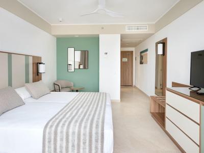 Camera d'hotel moderna con letto matrimoniale, TV e decorazione minimalista.