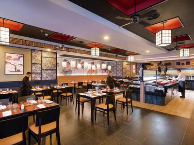 Ristorante moderno con mobili in legno e decorazioni asiatiche per pasti rilassati.