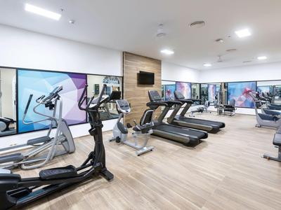 Moderne fitnessruimte met loopbanden, crosstrainers en grote ramen