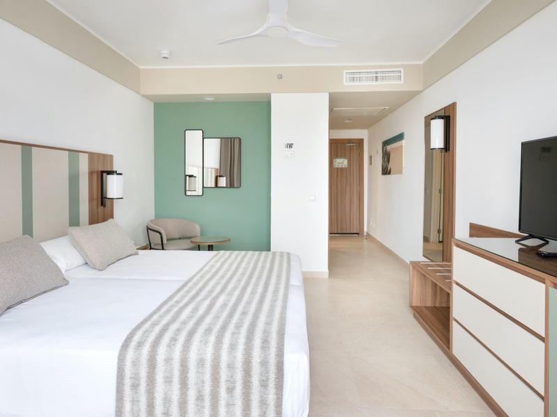 Camera d'hotel moderna con letto matrimoniale, TV e decorazione minimalista.