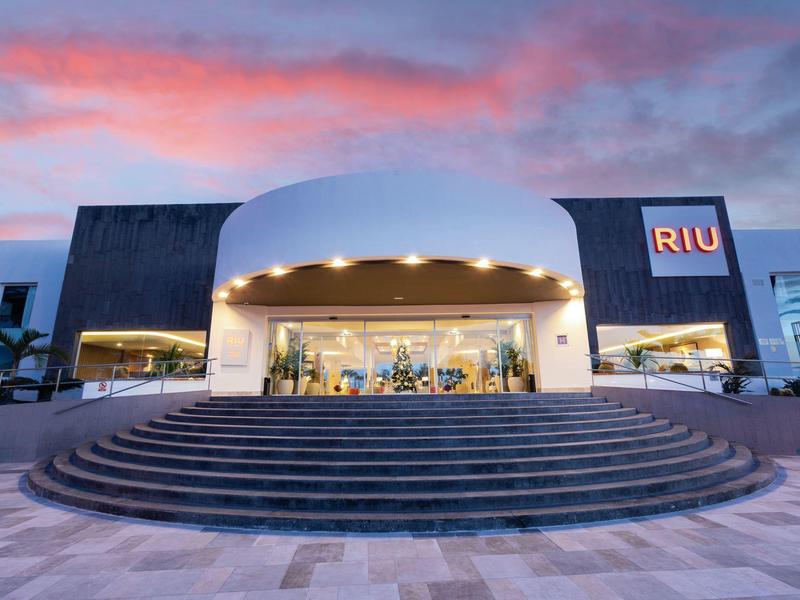 Hotel moderno con ingresso rotondo e ampie scale al tramonto.