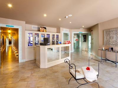 Hall d'hôtel lumineux avec un comptoir de réception et un coin salon confortable.